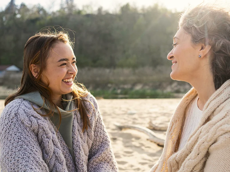 Two women talking on a beach
